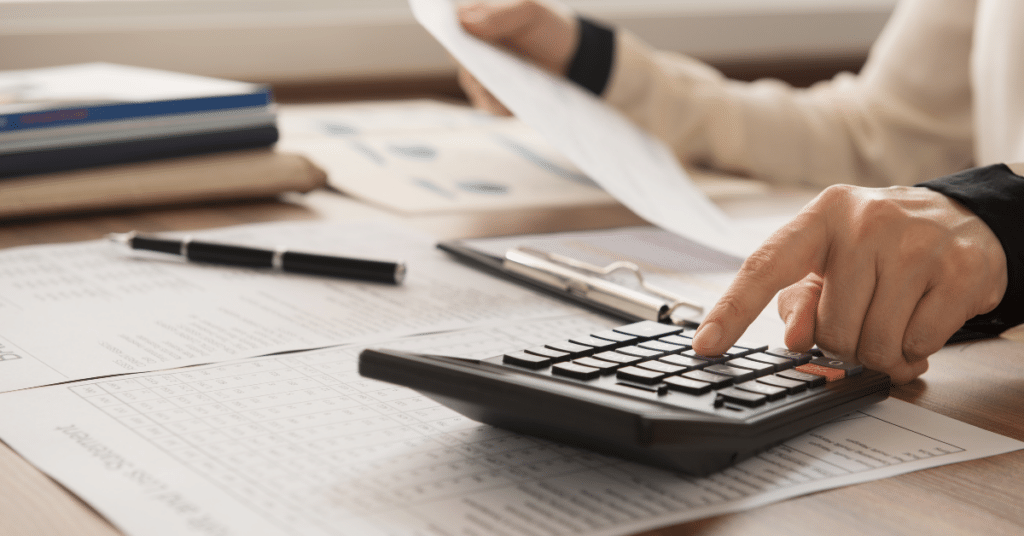 person working on documents and calculator