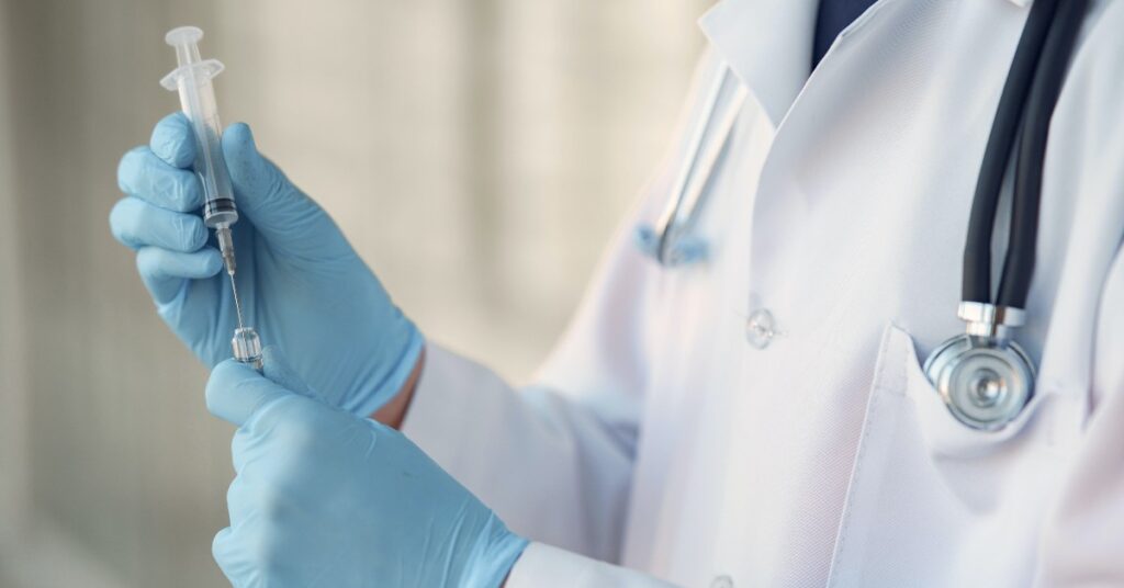 Doctor holding injection syringe